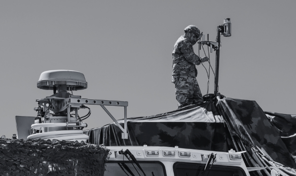 Decorative image of soldier standing and working on a beacon